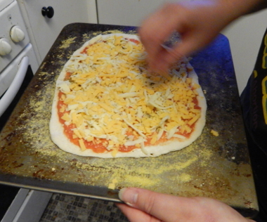 Going to the oven, rescue any stray pieces of cheese that aren't on the pizza.